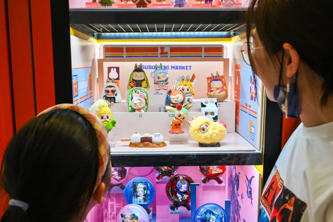 北京市民在一家商场内的泡泡玛特自动售卖机上,选购LABUBU等盲盒玩具。视觉中国图